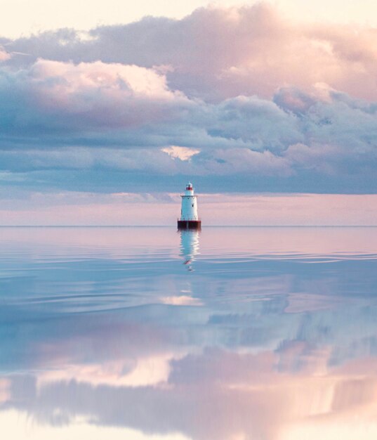 写真 夕暮れの空に照らされた海の灯台