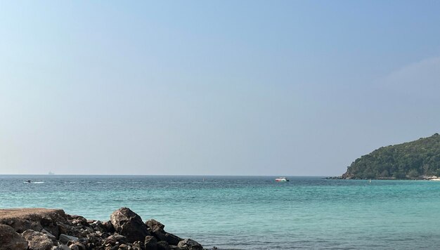 Photo a lighthouse is seen in the distance on a beach.