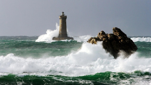 a lighthouse is in the water with the lighthouse in the background