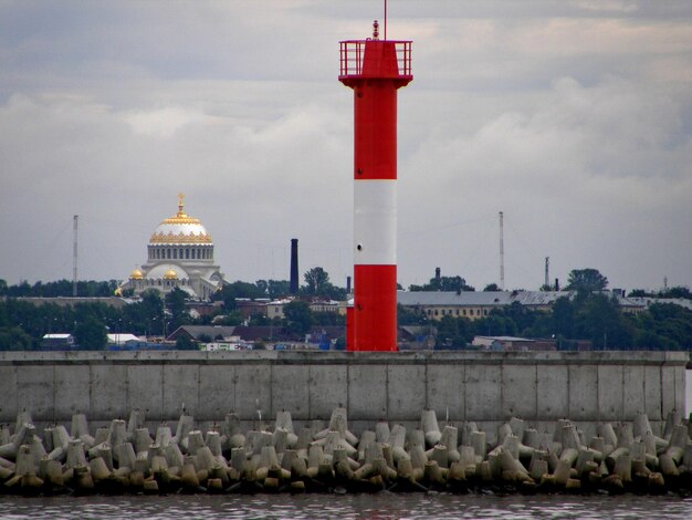 Lighthouse on the Kronstadt embankment against the backdrop of the naval cathedral Russia