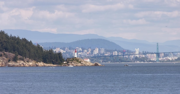 Lighthouse park modern city in background during sunny summer day