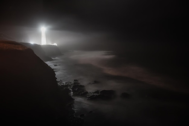 Lighthouse on the rocky coast by the Atlantic Ocean