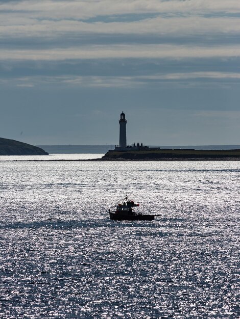 Lighthouse sailing on sea against sky