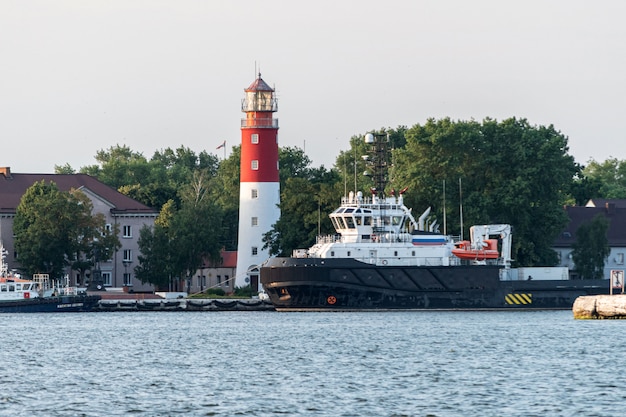 Lighthouse in seaport. Beautiful russian Baltiysk beacon. Clean blue sky.