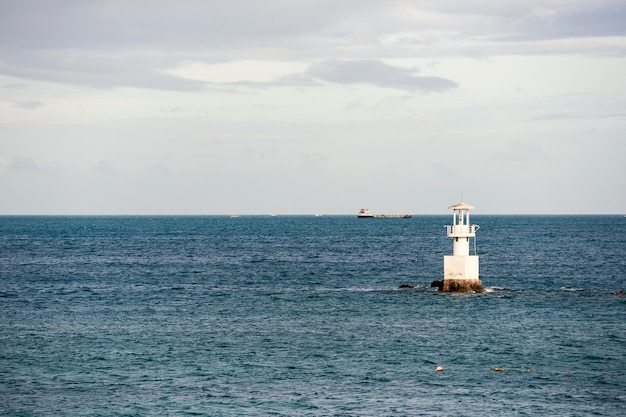 Lighthouse and ship in the sea.