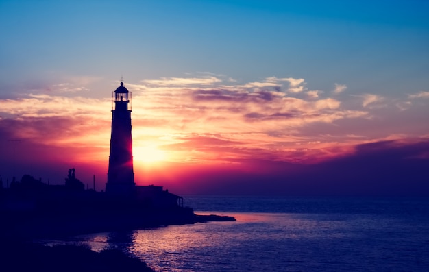 Lighthouse at the sunset on the beach