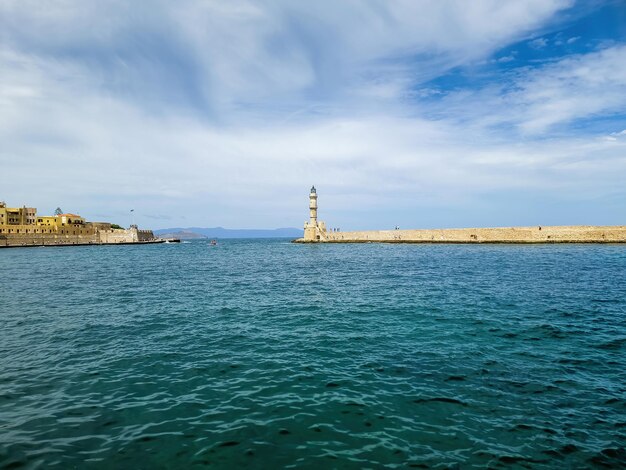 Lighthouse at Venetian harbour in Old Town of Chania Wavy sea city building Crete island Greece