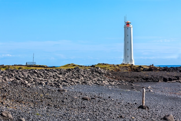 Foto faro sulla costa occidentale dell'islanda a tempo soleggiato. inquadratura orizzontale