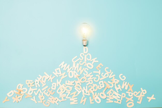 lighting bulb with alphabet wood on blue background