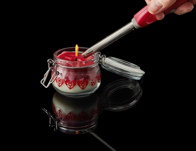 Lighting candle on black background with aromas of vanilla cherry pomegranate and coconut