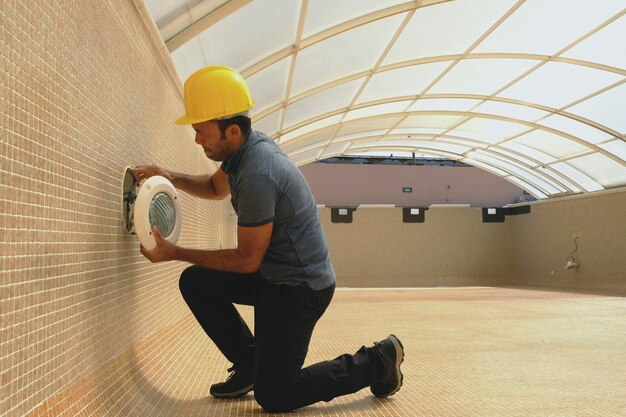 lighting technician working on the refurbishment of an empty swimming pool