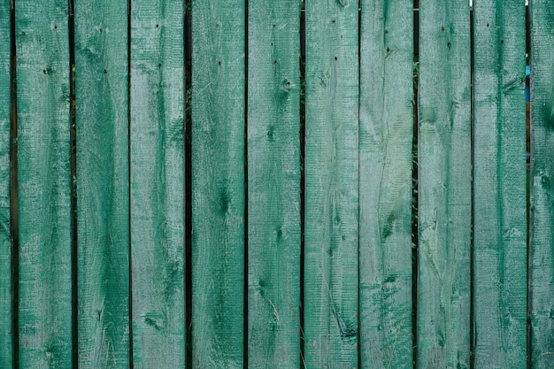 손톱으로 부착 된 녹색 질감의 가볍게 칠한 판자 울타리
