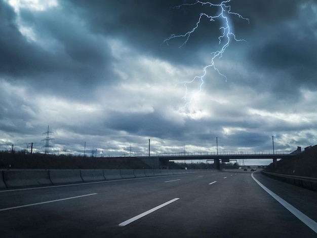 曇った空の道路上で稲妻が光る