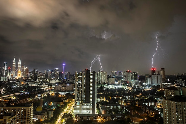 Foto il fulmine sul paesaggio cittadino illuminato di notte