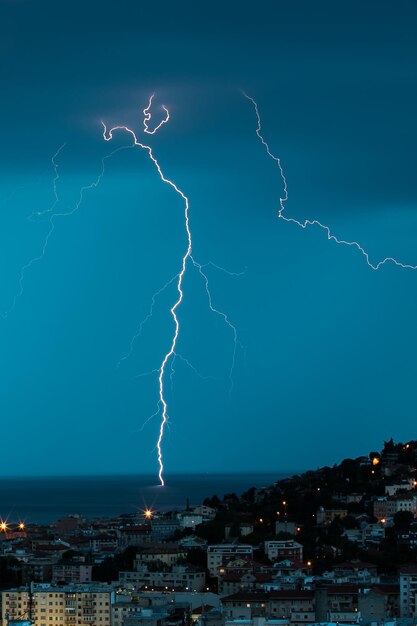 Foto il fulmine sul mare per la città al crepuscolo