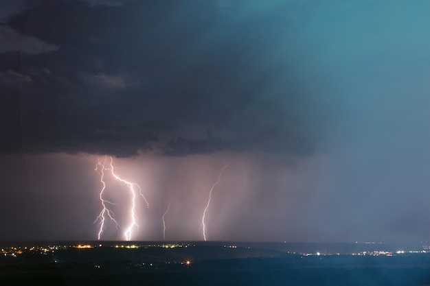 街に雷雨。夜の街の紺碧の空に落雷。