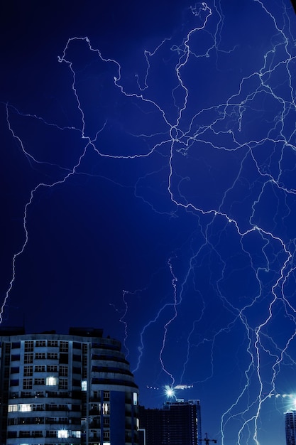 Lightning strikes over a building in a dark night sky.