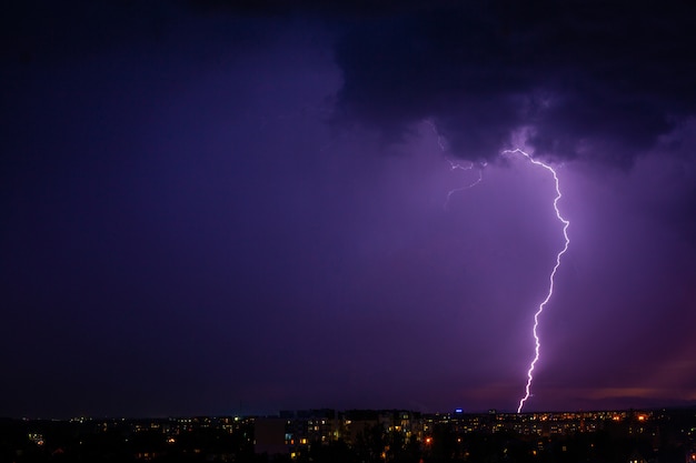 雷が都市の紫色の光に嵐を打ちます。