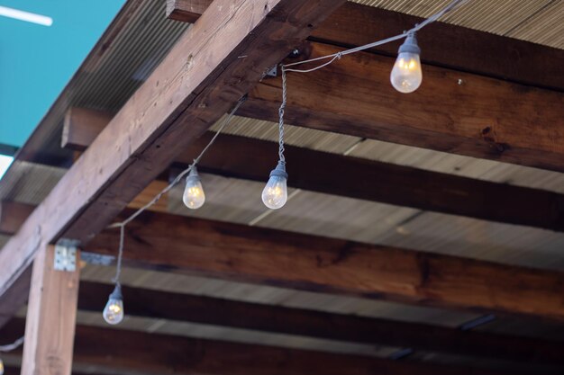Lights dangle from a wooden beam casting a warm glow