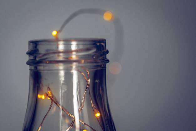 Photo lights garland in a glass bottle on a dark