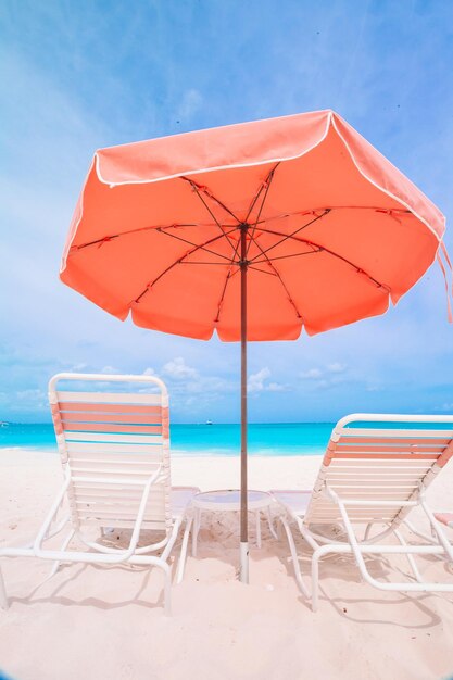 Ligstoelen en parasols op het strand tegen de blauwe hemel