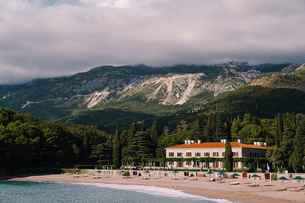 Ligstoelen en parasols op het strand villa milocer montenegro