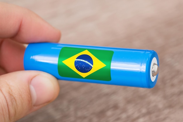 Liion battery with flag of Brazil in hand Production of batteries in Brazil concept