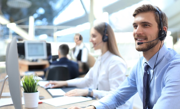 Lijn van callcentermedewerkers die aan computers werken.