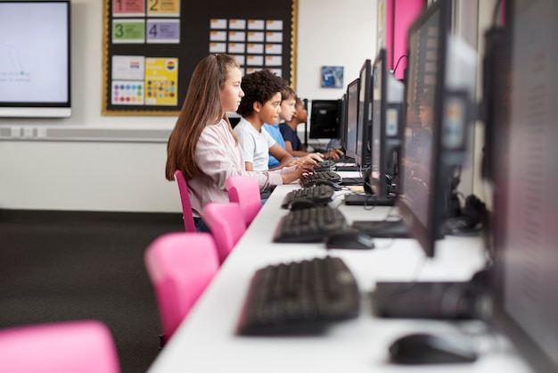 Lijn van middelbare scholieren die werken op schermen in de computerklas