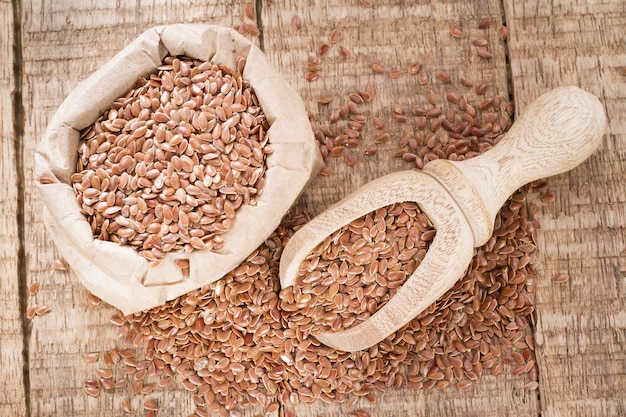 Lijnzaadzaden in bakje en lepel op tafel