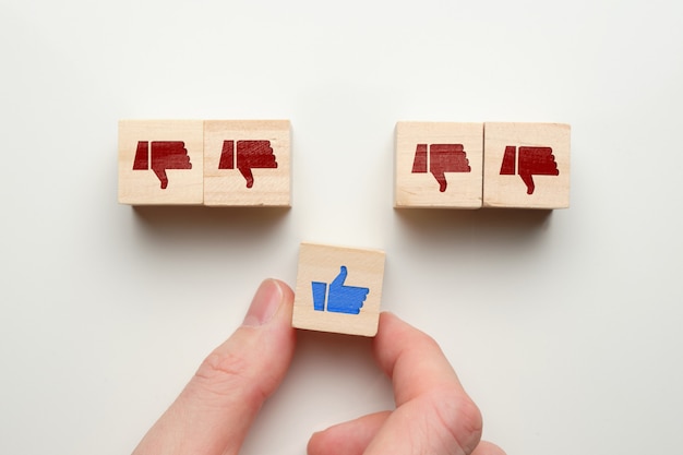 Like dislike concept on wooden cubes with hand.