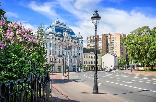 Lila bloemen en het flatgebouw van D. Elkind aan de Bolshaya Nikitskaya-straat in Moskou op een zonnige zomerdag