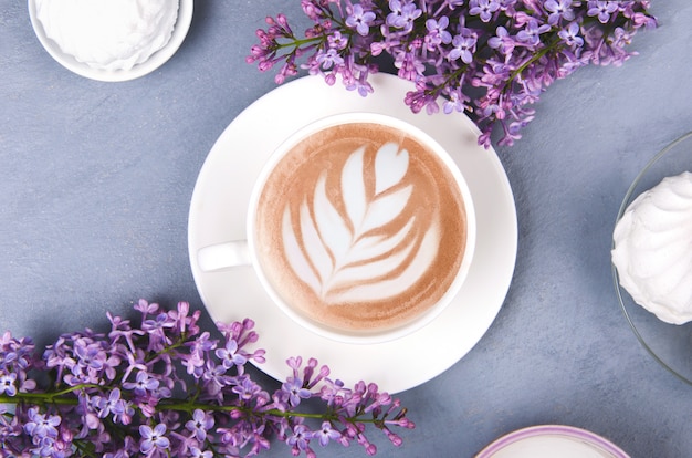 Lila, koffie met latte kunst en marshmallow op grijze houten tafel. Romantische plat lag