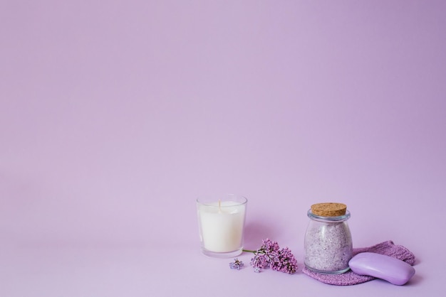 Lila spa Zeezout washandje want lila bloemen zeezoutkaars en handgemaakte zeep Natuurlijke kruidencosmetica met bloemen op een paarse achtergrond Ontspanningsconcept Cosmetische ingrepen Kopieer ruimte