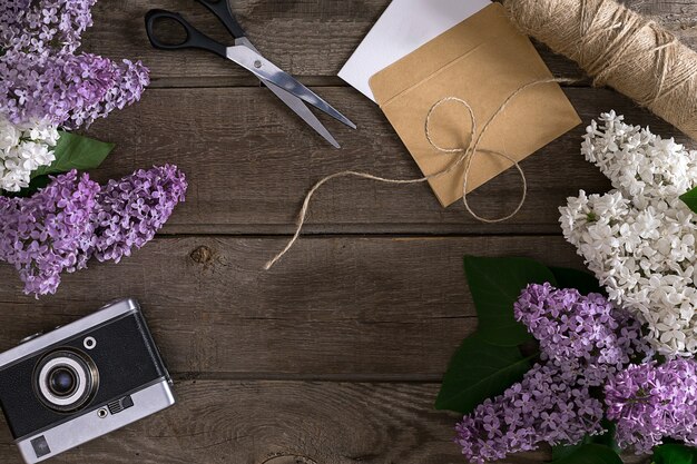 Lilac blossom on rustic wooden background with empty space for greeting message scissors thread reel...