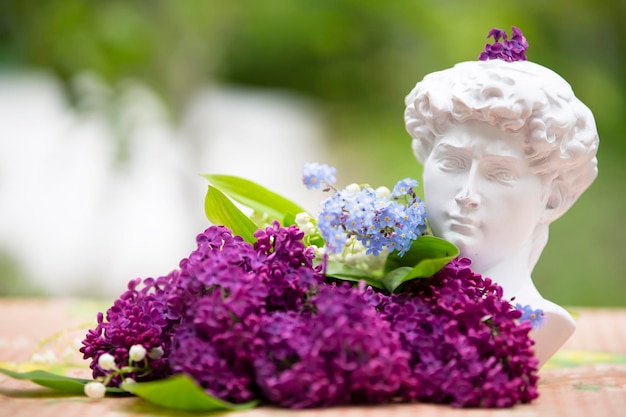 Lilac branches lie with the head of Michelangelo The concept of creativity and art