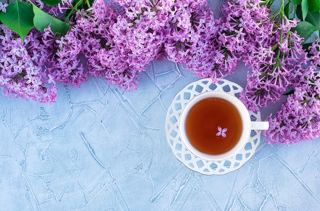 Lilac and Cup and saucer on a gray background The concept of Good morning romantic Flatley