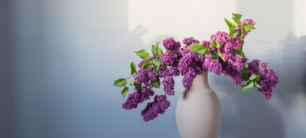 Lilac flowers in vase on wooden floor