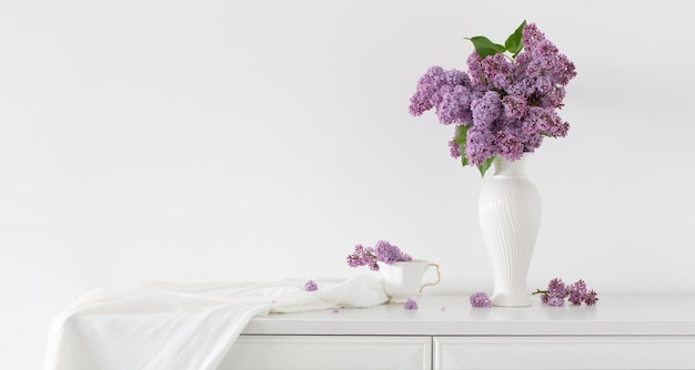 Fiori lilla in vaso bianco su sfondo bianco muro