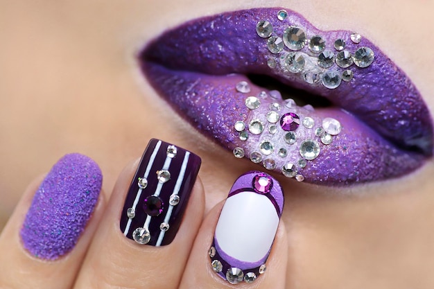 Photo lilac lips with rhinestones and manicure