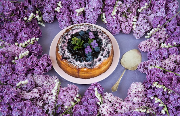 lilacs and lilies of the valley are lined with a frame and a cake with blueberries