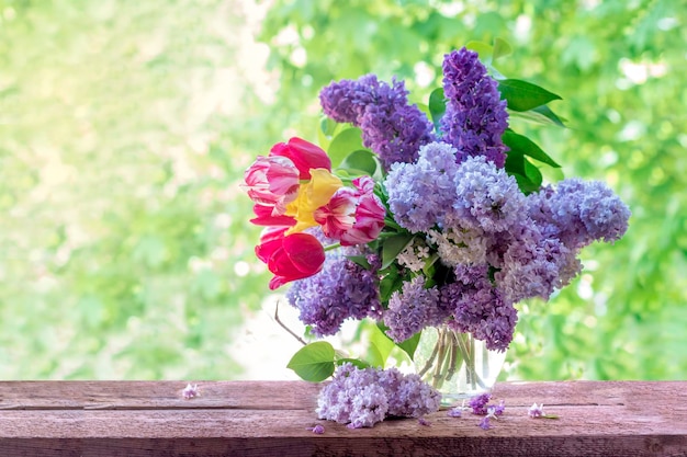 Lilacs and tulips in a vase on the windowBeautiful and delicate flowers