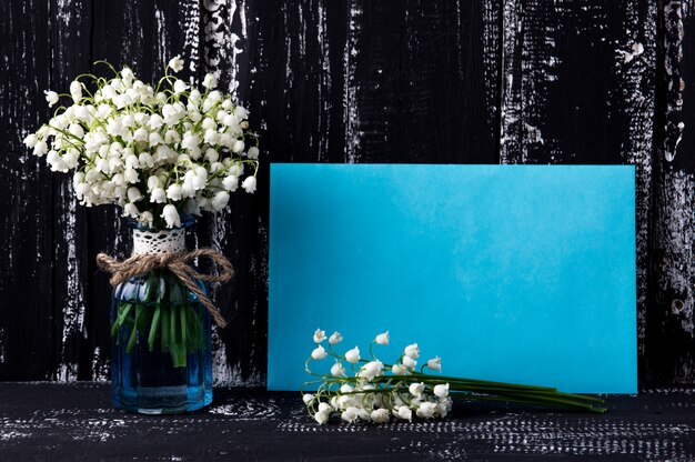 Photo lily of the valley on dark wooden table. lily of the valley bouquet.