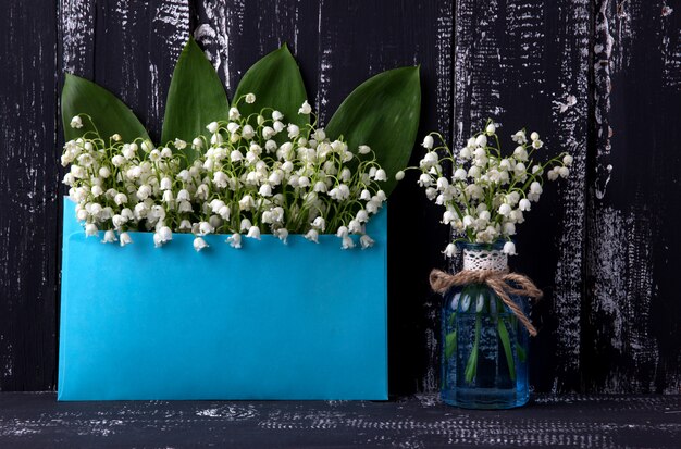 Lily of the valley on dark wooden table. Lily of the valley bouquet.