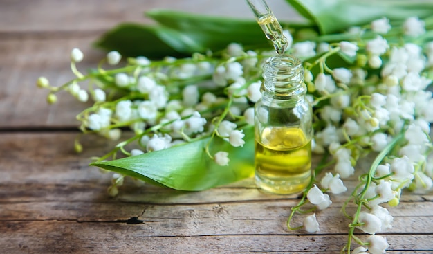 Lily of the valley essential oil in a small bottle. Selective focus. Nature.