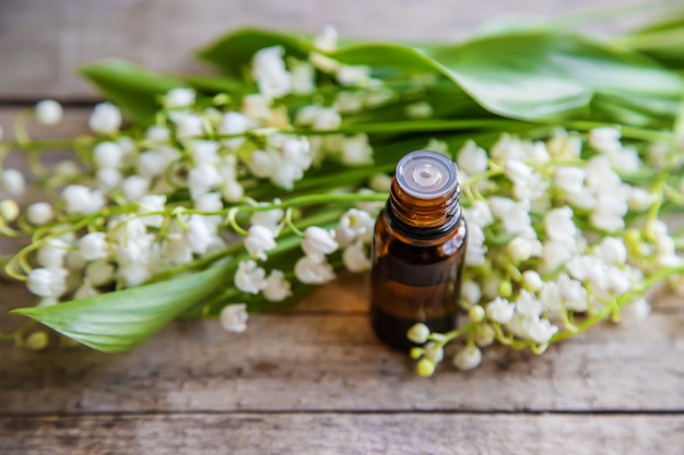 Lily of the valley essential oil in a small bottle. Selective focus. Nature.