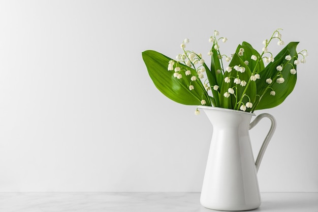 Lily of the valley flowers bouquet in vase on white background womans day or wedding background