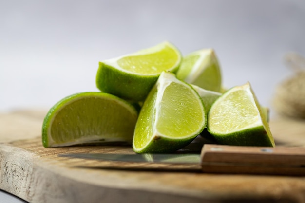 Lime cut into pieces lying on a wooden board