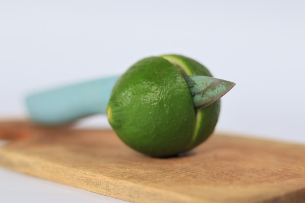 A lime on a cutting board with a handle