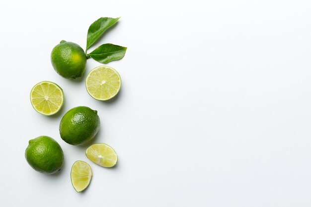 Lime fruits with green leaf and cut in half slice isolated on white background Top view Flat lay with copy space